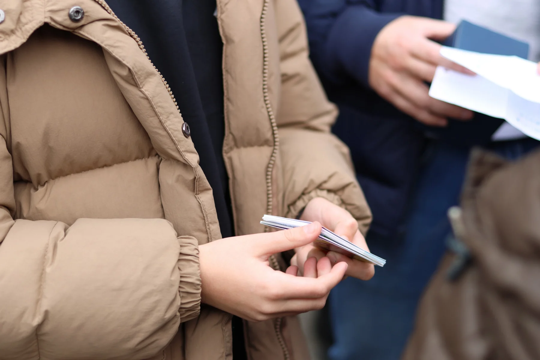 Person in a brown jacket writing