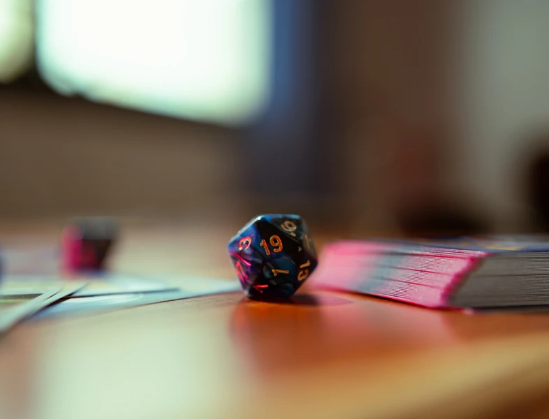 D20 dice next to a deck of cards.